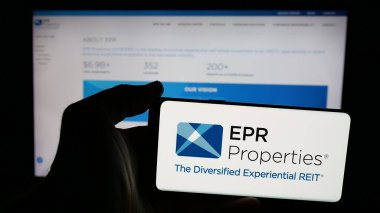 Stuttgart, Almanya - 11-07-2024: ABD 'li emlak şirketi EPR Properties' in logosuna sahip cep telefonu sahibi kişi iş sayfasının önünde ekranda. Telefon ekranına odaklan.