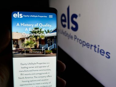 Stuttgart, Almanya - 11-07-2024: ABD 'li Equity Lifestyle Properties Inc. (ELS) şirketinin web sayfasını elinde tutan kişi logo ile ekranda. Telefon ekranının merkezine odaklan.