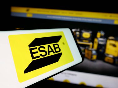 Stuttgart, Almanya - 11-07-2024: Sanayi şirketi ESAB Corporation 'ın logosunun yer aldığı cep telefonu iş sitesinin önünde ekranda. Telefon ekranının merkez soluna odaklan.
