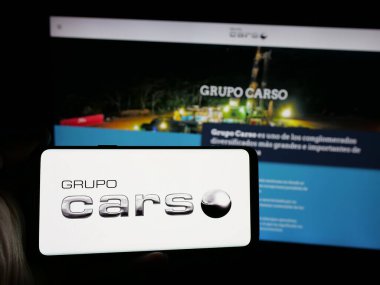 Stuttgart, Almanya - 11-08-2024: Meksikalı Grupo Carso S.A.B. şirketinin logosuna sahip akıllı telefon sahibi kişi de C.V. web sitesinin önünde ekranda. Telefon ekranına odaklan.