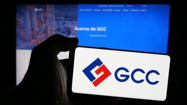 Stuttgart, Almanya - 11-08-2024: Üzerinde Meksikalı çimento şirketi GCC S.A.B. logosu olan cep telefonu tutan kişi De C.V. iş dünyasının web sayfasının önünde. Telefon ekranına odaklan.