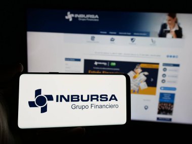 Stuttgart, Almanya - 11-08-2024: Grupo Financiero Inbursa S.A.B. şirketinin logosuna sahip akıllı telefon sahibi kişi de C.V. web sitesinin önünde ekranda. Telefon ekranına odaklan.