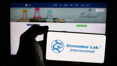 Stuttgart, Almanya - 11-11-2024: Genomma Lab Internacional S.A.B. logosuna sahip cep telefonu sahibi kişi de C.V. web sayfasının önünde ekranda. Telefon ekranına odaklan.