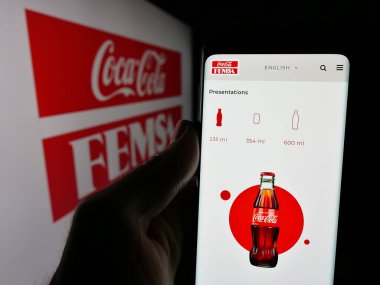 Stuttgart, Almanya - 11-11-2024: Meksikalı Coca-Cola FEMSA S.A.B. De CV ekranda logonun önünde. Telefon ekranının merkezine odaklan.