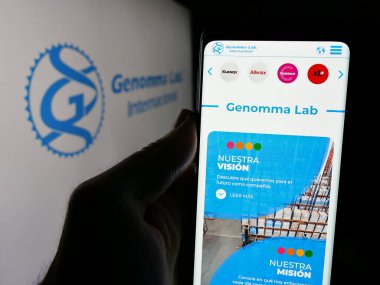Stuttgart, Almanya - 11-11-2024: Logo önünde ekranda Genomma Lab Internacional SAB de CV şirketinin web sayfası ile akıllı telefon tutan kişi. Telefon ekranının merkezine odaklan.