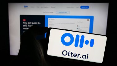 Stuttgart, Almanya - 12-27-2023: ABD 'li yapay istihbarat şirketi Otter.ai Inc.' in logosunun bulunduğu cep telefonu sahibi kişi iş sayfasının önünde. Telefon ekranına odaklan.