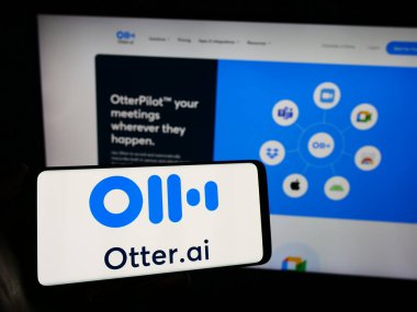 Stuttgart, Almanya - 12-27-2023: İnternet sayfasının önünde üzerinde Amerikan Yapay Zeka Şirketi Otter.ai Inc logosu olan cep telefonu sahibi kişi. Telefon ekranına odaklan.
