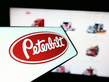 Stuttgart, Almanya - 12-27-2023: İnternet sitesi önünde ABD 'li kamyonet üreticisi Peterbilt Motors Company' nin logosuna sahip akıllı telefon. Telefon ekranının merkez soluna odaklan.