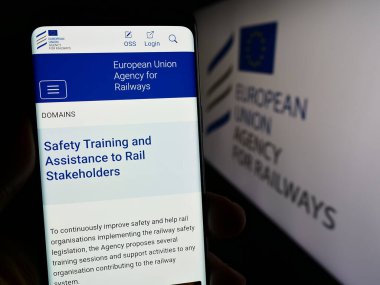 Stuttgart, Almanya - 12-27-2023: AB kurumu Avrupa Demiryolları Dairesi 'nin (ERA) logolu İnternet sitesi ile cep telefonu bulunduran kişi. Telefon ekranının merkezine odaklan.