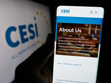 Stuttgart, Almanya - 12-29-2023: Avrupa Bağımsız Sendikalar Konfederasyonu 'nun (CESI) logolu web sayfası ile cep telefonu tutan kişi. Telefon ekranının merkezine odaklan.