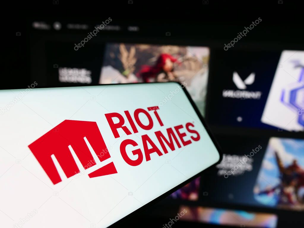 Stuttgart, Germany - 12-27-2023: Cellphone with logo of American video game development company Riot Games Inc. in front of website. Focus on center-left of phone display.