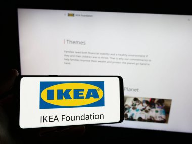 Stuttgart, Almanya - 12-29-2023: İnternet sitesi önünde IKEA Vakfı logosu taşıyan kişi. Telefon ekranına odaklan.