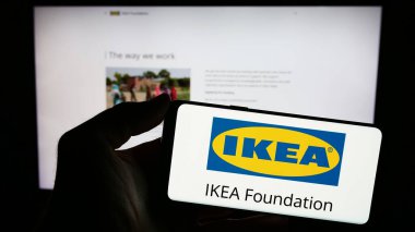 Stuttgart, Almanya - 12-29-2023: İnternet sayfası önünde IKEA Vakfı logosu taşıyan kişi. Telefon ekranına odaklan.