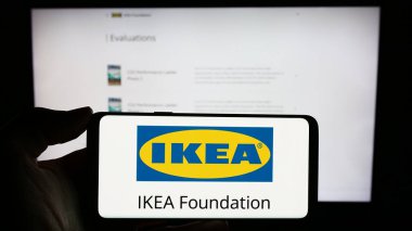 Stuttgart, Almanya - 12-29-2023: İnternet sayfası önünde IKEA Vakfı logosu olan kişi. Telefon ekranına odaklan.