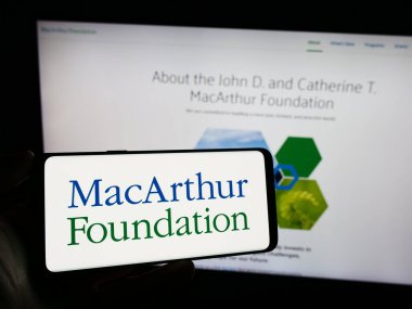 Stuttgart, Almanya - 12-29-2023: Cep telefonunda John D. ve Catherine T. MacArthur Vakfı 'nın logosu olan kişi web sayfasının önünde. Telefon ekranına odaklan.