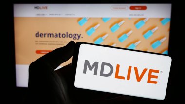 Stuttgart, Almanya - 12-31-2023: İnternet sitesi önünde ABD 'li sanal sağlık hizmetleri şirketi MDLIVE' ın logosunu taşıyan kişi. Telefon ekranına odaklan.