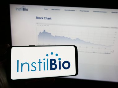 Stuttgart, Almanya - 12-31-2023: Amerikan biyoteknoloji şirketi Instil Bio Inc. 'nin logosu olan cep telefonu sahibi kişi iş sayfasının önünde. Telefon ekranına odaklan.