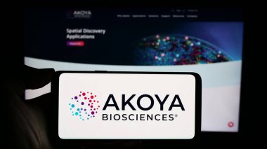 Stuttgart, Almanya - 12-31-2023: ABD 'li biyoteknoloji şirketi Akoya Biosciences Inc.' in logosuna sahip akıllı telefon sahibi kişi web sitesi önünde. Telefon ekranına odaklan.