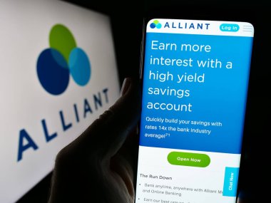 Stuttgart, Almanya - 02-03-2024: ABD finans kurumu Alliant Credit Union 'un logo önündeki web sayfası ile cep telefonu tutan kişi. Telefon ekranının merkezine odaklan.
