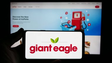Stuttgart, Almanya - 02-03-2024: İnternet sitesinin önünde ABD 'li süpermarket zincir şirketi Giant Eagle Inc.' in logosuna sahip kişi. Telefon ekranına odaklan.