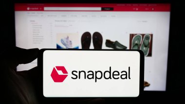 Stuttgart, Almanya - 02-06-2024: Üzerinde Hint e-ticaret şirketi Snapdeal Limited 'in logosu bulunan cep telefonu sahibi kişi iş sayfasının önünde. Telefon ekranına odaklan.