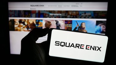 Stuttgart, Almanya - 02-06-2024: Japon oyun şirketi Square Enix Holding Co. Ltd. nin logosuna sahip akıllı telefon sahibi kişi web sitesinin önünde. Telefon ekranına odaklan.