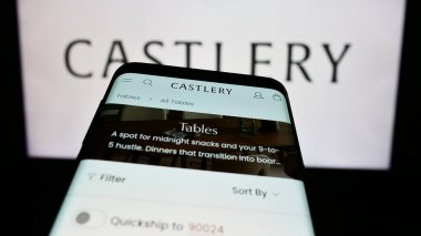 Stuttgart, Almanya - 02-07-2023: Singapur mobilya e-ticaret şirketi Castlery 'nin web sitesi ile ticaret logosu önünde akıllı telefon. Telefon ekranının sol üst kısmına odaklan.