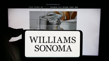 Stuttgart, Almanya - 02-08-2024: İş sayfası önünde ABD 'li tüketici perakende şirketi Williams-Sonoma Inc.' in logosuyla cep telefonu tutan kişi. Telefon ekranına odaklan.