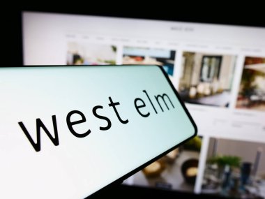 Stuttgart, Almanya - 02-08-2024: Ev dekorasyonu şirketi West Elm 'in logosunun yer aldığı cep telefonu iş sitesinin önünde. Telefon ekranının merkez soluna odaklan.