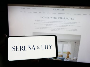 Stuttgart, Almanya - 02-08-2024: Web sitesi önünde ABD 'li ev tasarım şirketi Serena ve Lily Inc.' in logosuna sahip kişi. Telefon ekranına odaklan.