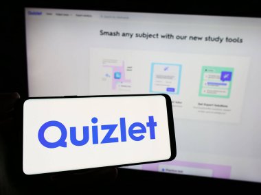 Stuttgart, Almanya - 02-08-2024: Amerikan çevrimiçi öğrenme şirketi Quizlet Inc. 'in logosuyla cep telefonu sahibi kişi iş sayfasının önünde. Telefon ekranına odaklan.