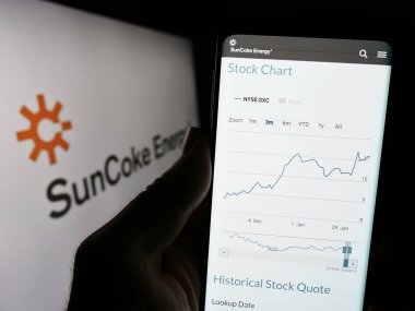 Stuttgart, Almanya - 02-11-2024: ABD 'li kokain üreticisi SunCoke Energy Inc.' in web sitesi ile logo önünde cep telefonu bulunduran kişi. Telefon ekranının merkezine odaklan.