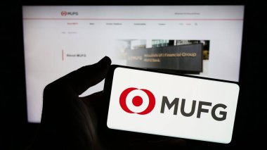 Stuttgart, Almanya - 02-11-2024: İnternet sitesi önünde Mitsubishi UFJ Financial Group Inc. (MUFG) şirketinin logosuna sahip kişi. Telefon ekranına odaklan.