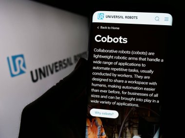 Stuttgart, Almanya - 02-12-2024: Logonun önünde Danimarkalı kobot şirketi Universal Robots AS 'nin web sitesiyle cep telefonu tutan kişi. Telefon ekranının merkezine odaklan.