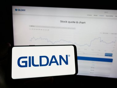 Stuttgart, Almanya - 02-13-2024: Kanadalı giyim şirketi Gildan Activewear Inc. 'in logosunu taşıyan cep telefonu sahibi şirket. Telefon ekranına odaklan.