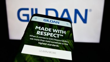 Stuttgart, Almanya - 02-13-2024: İş logosu önünde Kanadalı giyim şirketi Gildan Activewear Inc. 'in web sitesi ile cep telefonu. Telefon ekranının sol üst kısmına odaklan.