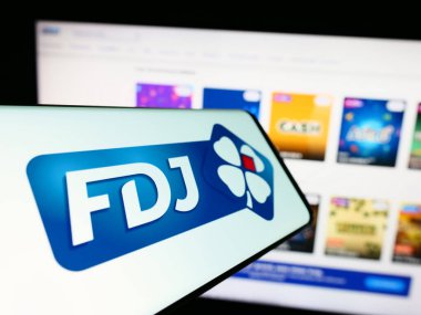 Stuttgart, Almanya - 02-13-2024: Fransız piyango şirketi Francaise des Jeux 'un logosuna sahip cep telefonu (FDJ) işletme web sitesinin önünde. Telefon ekranının merkezine odaklan.