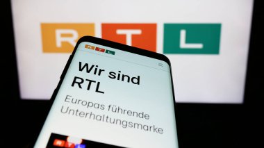 Stuttgart, Almanya - 02-13-2024: İş logosu önünde medya ve televizyon şirketi RTL Group S.A. 'nın web sayfası ile cep telefonu. Telefon ekranının sol üst kısmına odaklan.