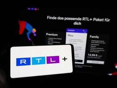 Stuttgart, Almanya - 02-13-2024: İnternet sitesinin önünde Alman eğlence platformu RTL artı logosu taşıyan kişi. Telefon ekranına odaklan.