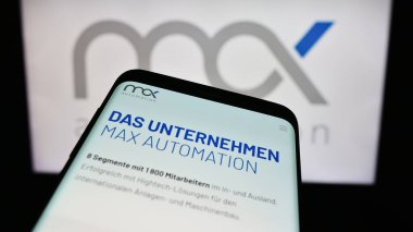 Stuttgart, Almanya - 02-13-2024: Alman mühendislik şirketi MAX Automation SE 'nin web sitesi ile ticaret logosu önünde akıllı telefon. Telefon ekranının sol üst kısmına odaklan.