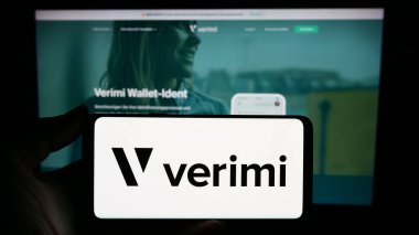 Stuttgart, Almanya - 02-15-2024: Alman kimlik yönetim şirketi Verimi GmbH 'nin logosuna sahip akıllı telefon sahibi kişi web sitesinin önünde. Telefon ekranına odaklan.