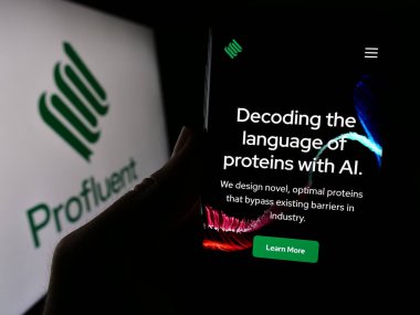 Stuttgart, Almanya - 02-16-2024: ABD 'li biyoteknoloji şirketi Profluent Bio' nun web sayfası ile iş logosu önünde cep telefonu tutan kişi. Telefon ekranının merkezine odaklan.