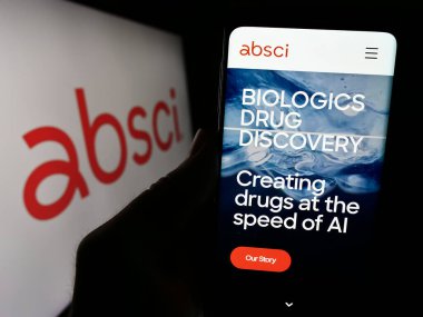 Stuttgart, Almanya - 02-16-2024: ABD 'li ilaç keşif şirketi Absci Corporation' ın web sitesi ile iş logosu önünde cep telefonu tutan kişi. Telefon ekranının merkezine odaklan.