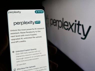 Stuttgart, Almanya - 02-16-2024: ABD 'li yapay zeka şirketi Perplexity AI' ın web sayfası ile logo önünde cep telefonu tutan kişi. Telefon ekranının merkezine odaklan.