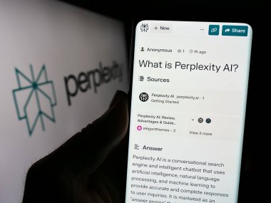 Stuttgart, Almanya - 02-16-2024: ABD 'li yapay zeka şirketi Perplexity Yapay Zeka' nın web sayfası logonun önünde duran kişi. Telefon ekranının merkezine odaklan.