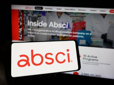 Stuttgart, Almanya - 02-16-2024: Amerikan ilaç keşif şirketi Absci Corporation 'ın logosuna sahip cep telefonu sahibi kişi iş sayfasının önünde. Telefon ekranına odaklan.