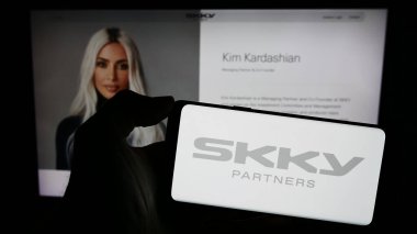 Stuttgart, Almanya - 02-19-2024: ABD 'li yatırım şirketi SKY Partners LP' nin logosuyla cep telefonu sahibi kişi iş sayfasının önünde. Telefon ekranına odaklan.