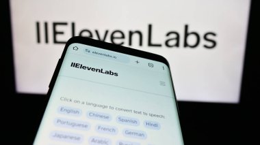 Stuttgart, Almanya - 02-19-2024: ABD 'li yapay istihbarat şirketi ElevenLabs Inc.' in web sitesi ile birlikte iş logosu önünde cep telefonu. Telefon ekranının sol üst kısmına odaklan.