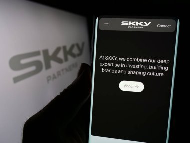 Stuttgart, Almanya - 02-19-2024: İş logosu önünde ABD 'li yatırım şirketi SKY Partners LP' nin web sayfası ile cep telefonu tutan kişi. Telefon ekranının merkezine odaklan.