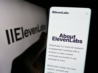 Stuttgart, Almanya - 02-19-2024: ABD 'li yapay zeka şirketi ElevenLabs Inc.' in web sayfası ile logo önünde akıllı telefon tutan kişi. Telefon ekranının merkezine odaklan.
